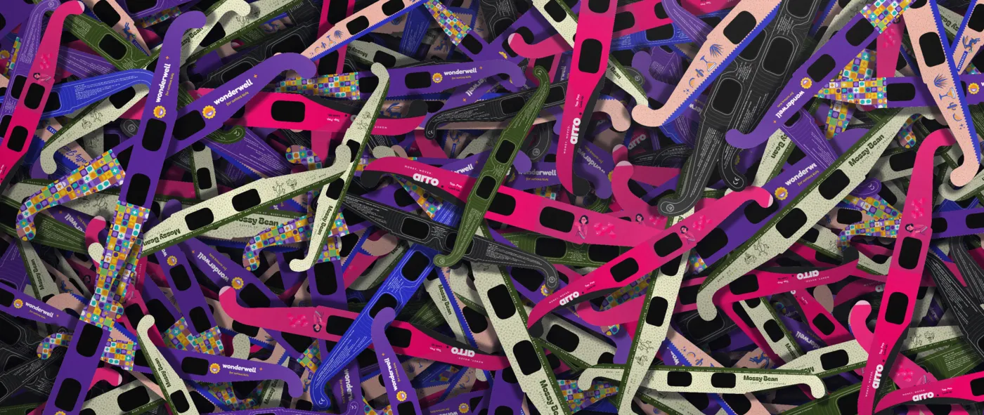 A pile of paper eclipse glasses printed with different brands and artwork