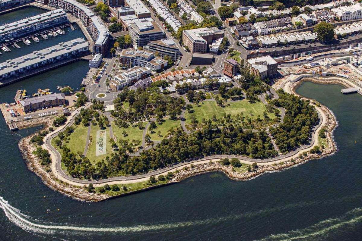 Aerial view of Barangaroo Reserve headland and its open lawns, surrounded by harbour water